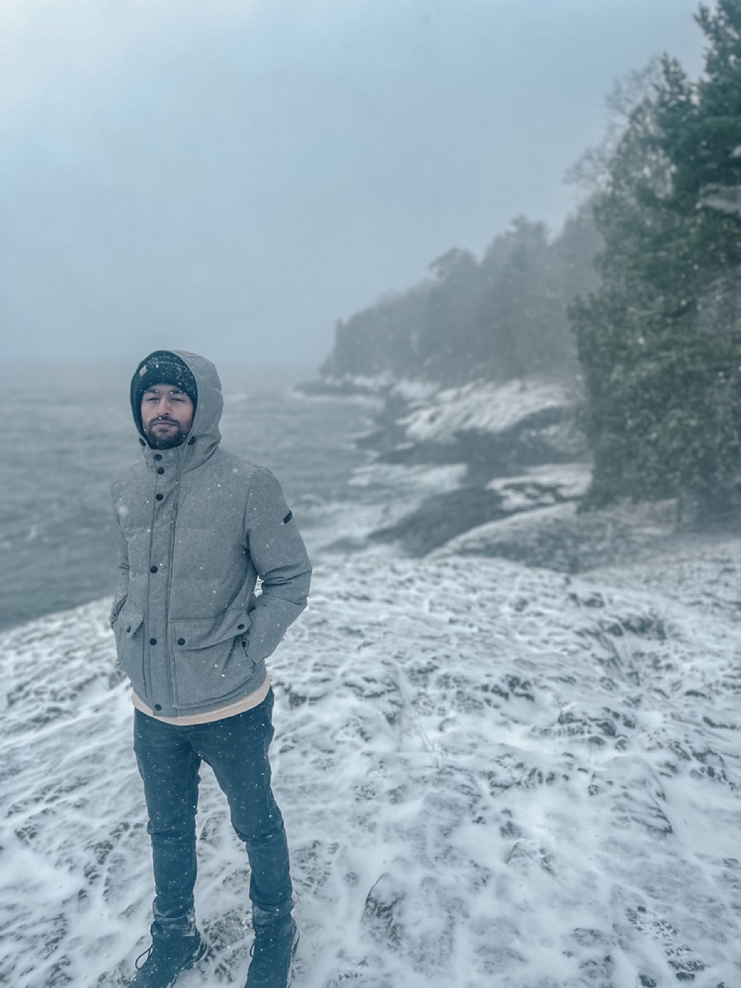 Vivek standing on a snowy shoreline